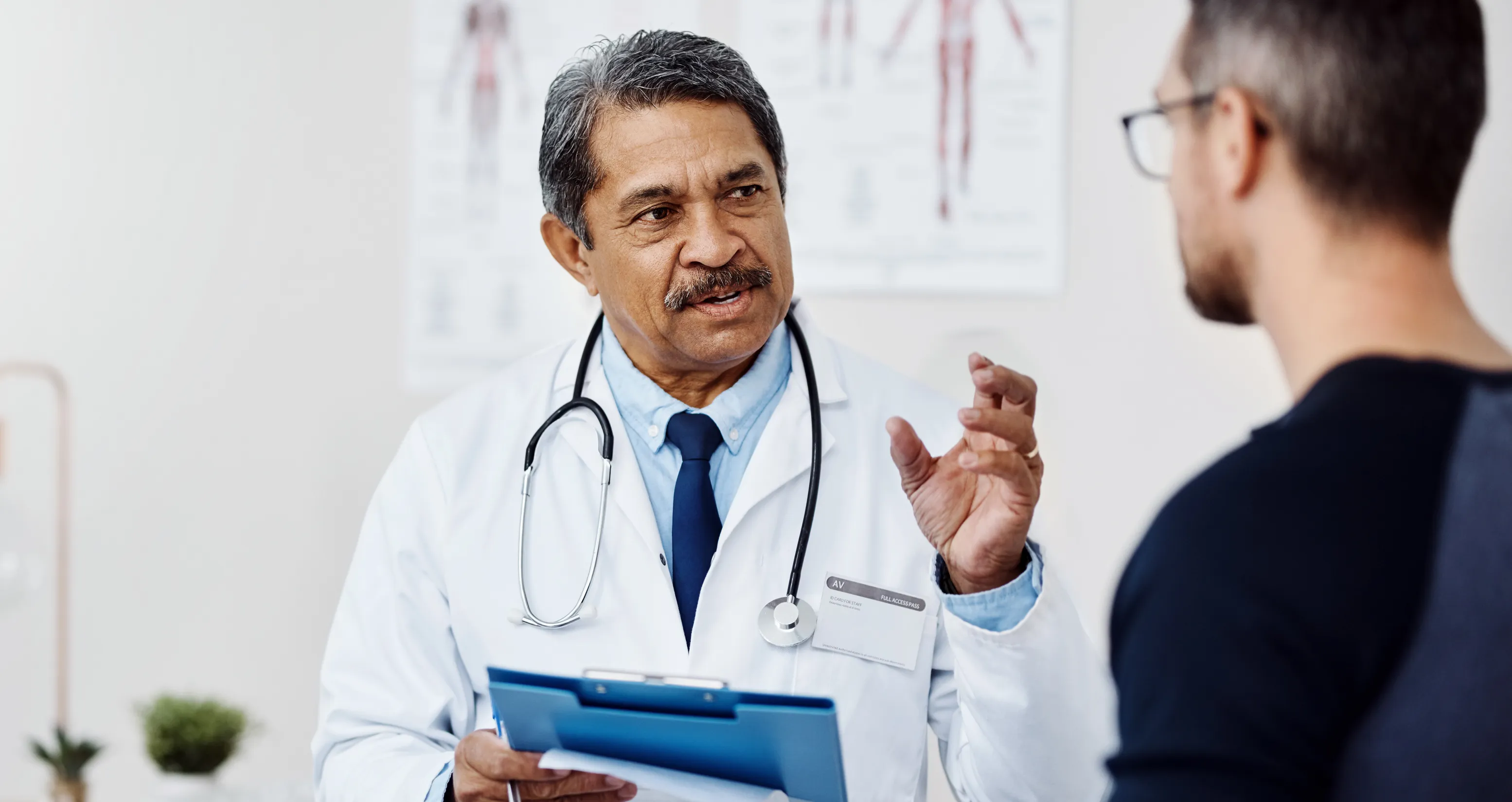 Male doctor consulting a male patient inside a medical setting