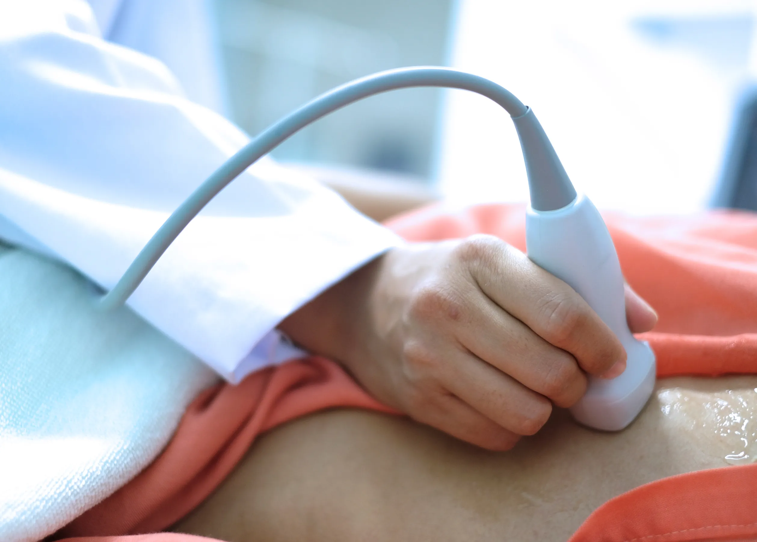 Close up of health care provider performing an echocardiogram on a patient