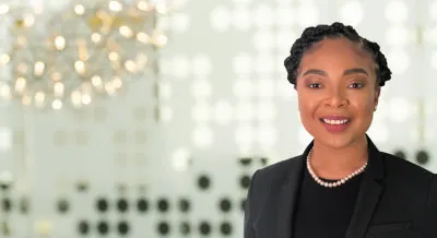Headshot of Naprisha Taylor off center with blurry background 